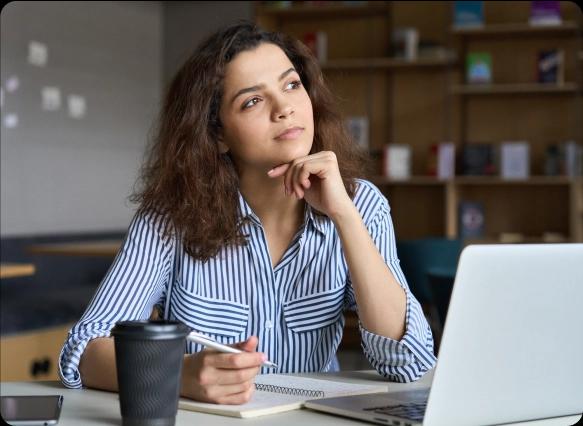 Foto de uma mulher pensando em frente ao seu laptop