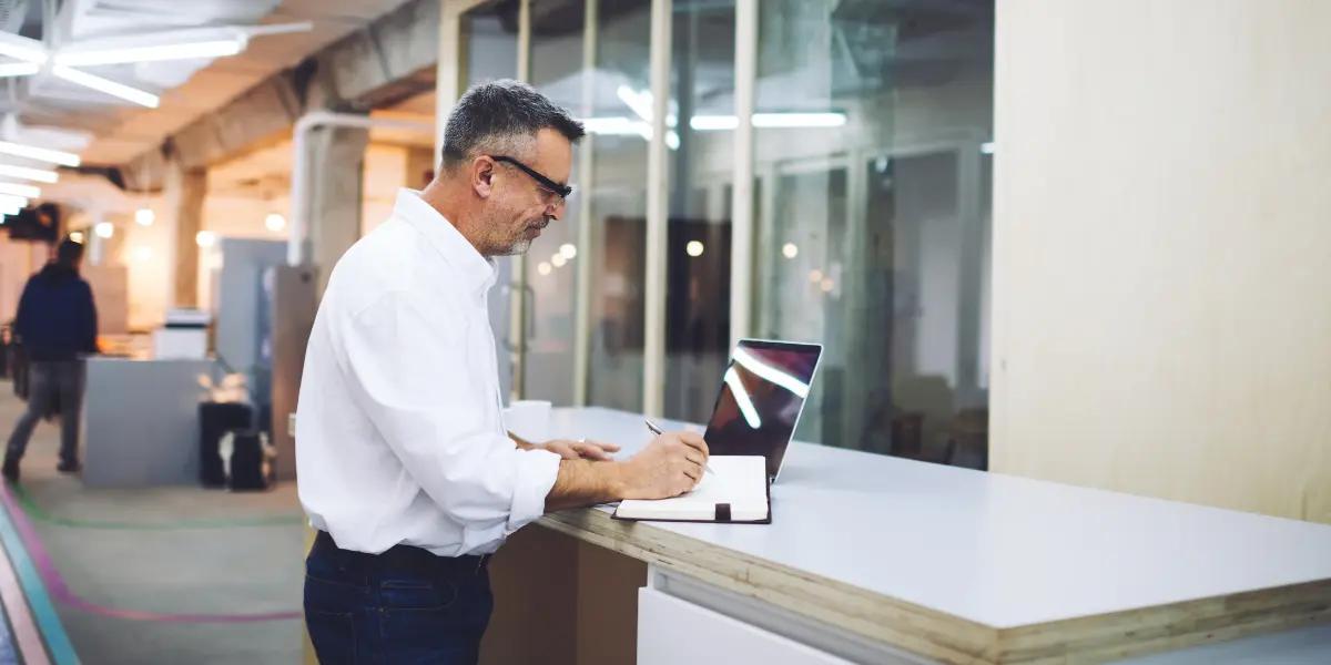 Imagem de um corretor pesquisando e anotando formas de como vender imóveis.