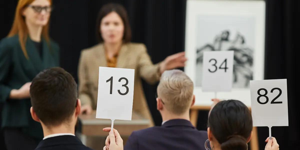 Imagem de corretores comprando propriedades em leilão de imóveis.