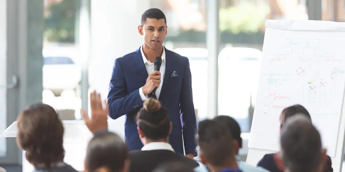 Corretor de imóveis apresentando pitch de vendas para clientes do mercado imobiliário.