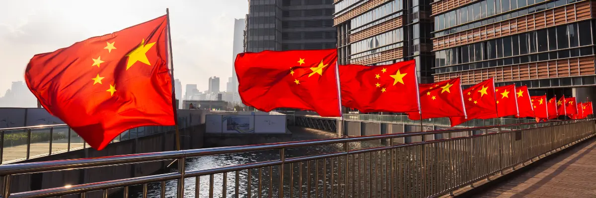 Imagem de bandeiras da China enfileiradas em ponto turístico do país.