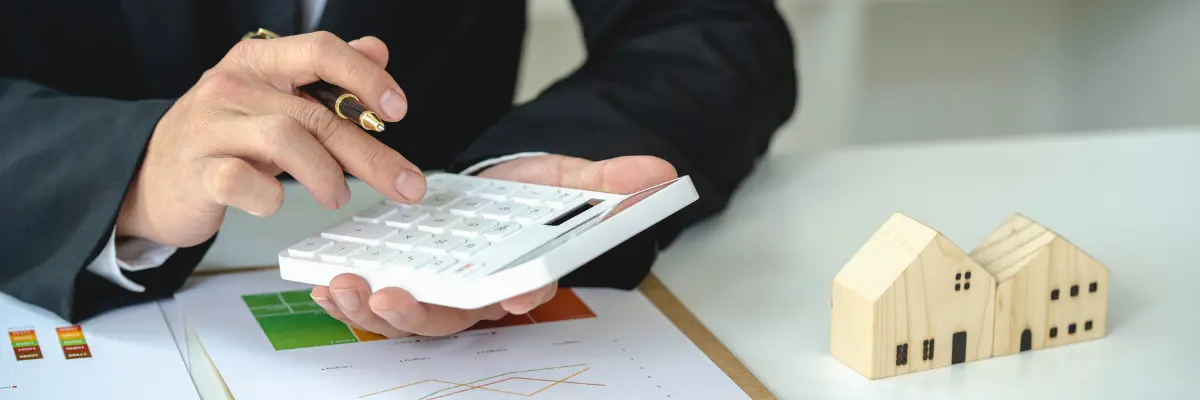 Imagem de um corretor de imóveis calculando o financiamento imobiliários depois do fim da poupança compulsória.