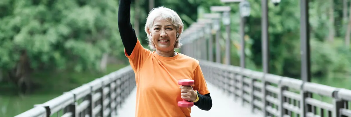 Mulher da 3º idade se exercitando ao ar livre na sua casa.