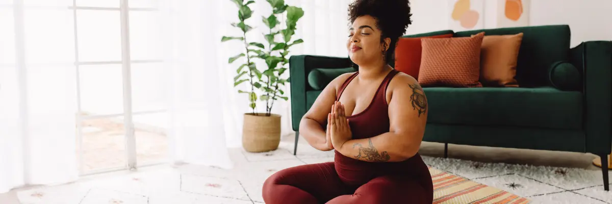 Jovem da Geração Z em seu imóvel próprio praticando Yoga.