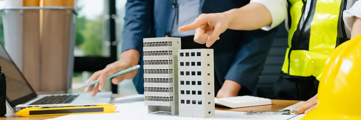 Engenheiros de uma construtora analisando projeto de lançamento imobiliário.