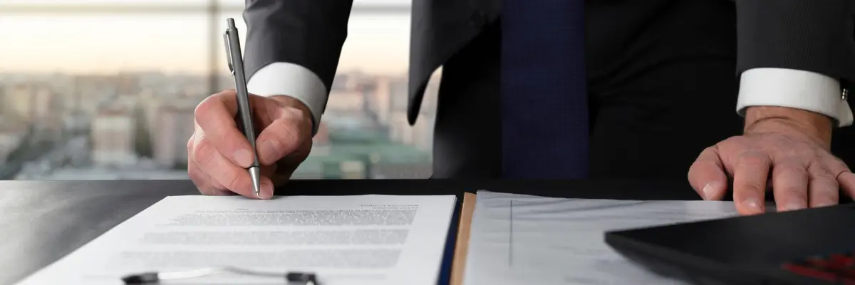 Corretor imobiliário assinando contrato do primeiro imóvel do seu cliente.