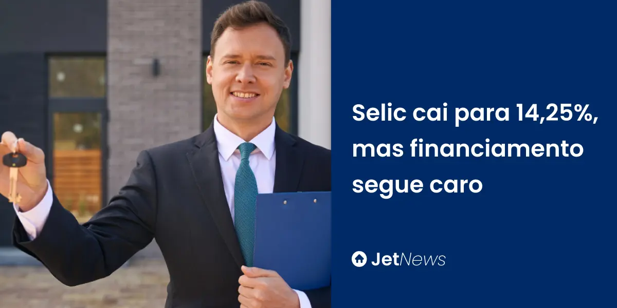 Corretor imobiliário usando terno preto e segurando chave de casa comprada através do financiamento.