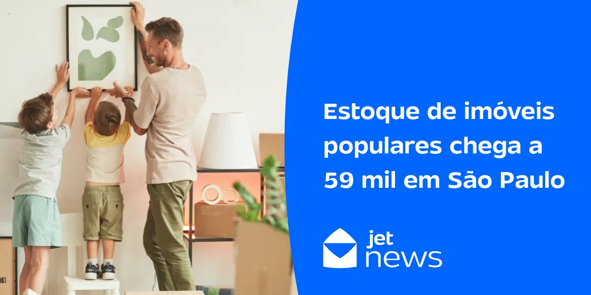 Família colocando um quadro na parede do seu novo apartamento.