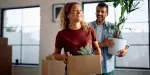 Jovem casal levando mudança para novo apartamento adquirido através do aluguel consignado.