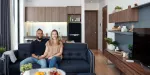 Casal sentados no sofá da sala de estar da sua residência de um dormitório.